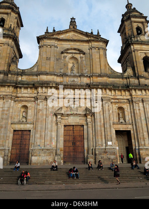 People sitting on the steps of Catedral Primada in Plaza de Bolivar. Stock Photo