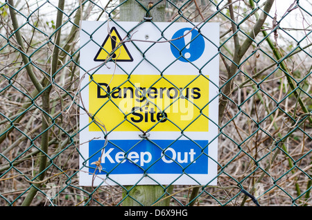 Sign attached to wire fence saying dangerous site, keep out Stock Photo