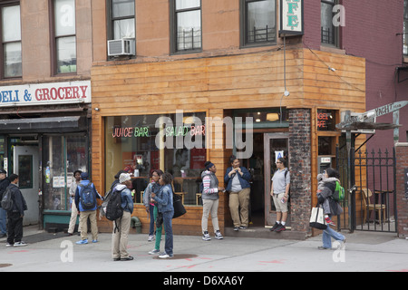 High School kids hanging out on Smith Street in the Carroll Gardens neighborhood after school in Brooklyn, NY. Stock Photo