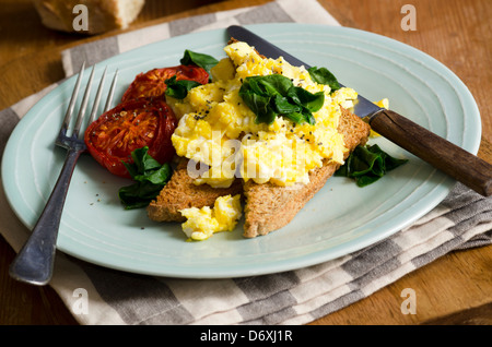 Scrambled eggs with spinach on toasted bread Stock Photo