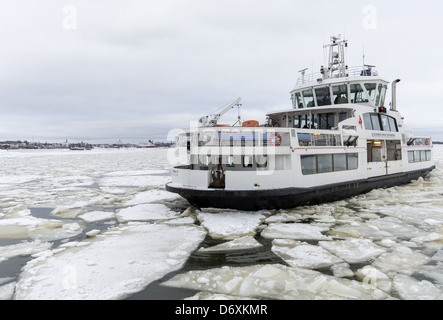 The ferry that goes from Suomenlinna island to Helsinki Harbour in the wintertime showing the sea covered in ice Stock Photo