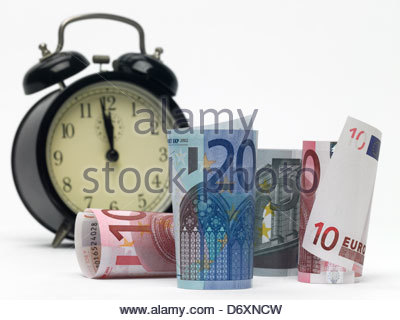 5,10 and 20 Euro notes rolled up standing and lying with alarm clock