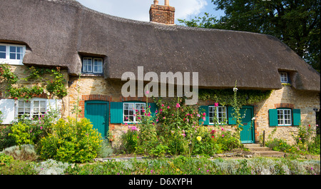 Quaint traditional thatched cottage, rose-covered, at Clifton Hampden in Oxfordshire, UK Stock Photo