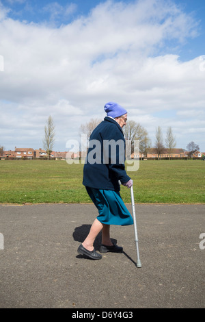 Ninety year old lady walking in park. England, UK Stock Photo