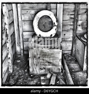 Dilapidated wooden toilet in outhouse Stock Photo