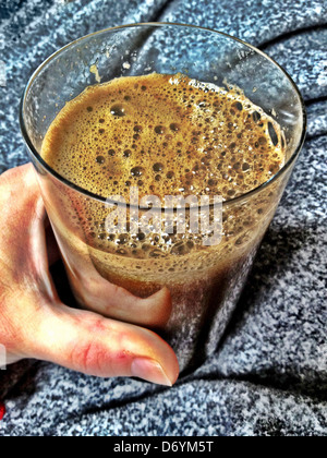 Hand holding glass of vegetable juice Stock Photo