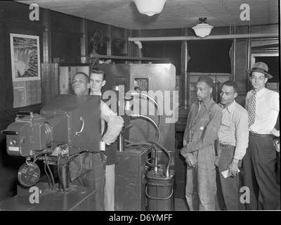 A photograph from Hopewell, Virginia, showing a United Mine Workers of America (UMWA) office during a health check-up with an X-ray machine. The image captures the intersection of labor and industrial health in the chemical factory industry. Stock Photo