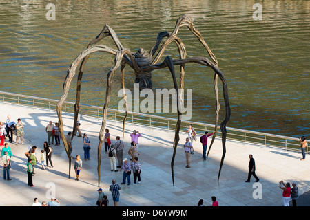 Tourists view spider bronze sculpture Maman by Louise Bourgeois at Guggenheim Museum in Bilbao, Basque country, Spain Stock Photo