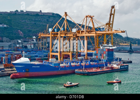 Container ship being refuelled while unloading in the port of Barcelona, Spain Stock Photo