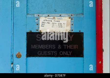 Club, old door and handwritten sign, opening hours. Stock Photo