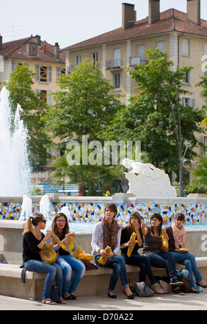 Young office workers eat sandwiches in Place Clemenceau during lunch break in Pau, the Pyrenees, France Stock Photo
