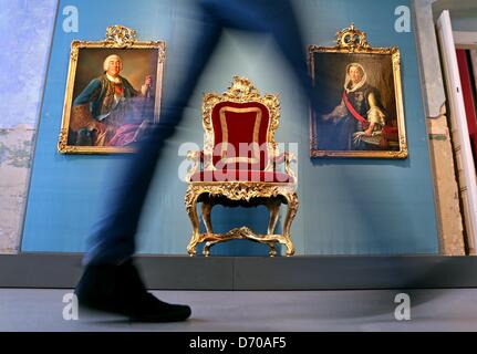 A young woman walks past the gilded audience chair and paintings of King Augustus III of Poland and his consort Maria Josepha of Austria from around 1755 at Hubertusburg Palace in Wermsdorf, Germany, 25 April 2013. The Dresden State Art Collections (SKD) is presenting a special exhibition to mark the 250th anniversary of the Peace Treaty of Hubertusburg in 1763 that ended the Seven Years' War. A few rooms were renovated in the empty palace at a cost of one million euros. Photo: JAN WOITAS Stock Photo