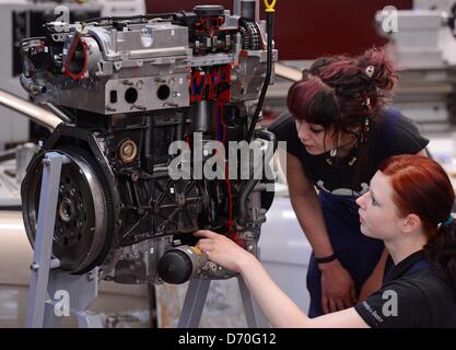 Apprentices Bianca Barthel (R) and Lisa Hannover look at a cutaway model of a car engine at the Girls' Day at the Mercedes-Benz site in Leizig, Germany, 25 April 2013. Bianca is on her second year of training to become a mechanic. Lisa is learning how to paint cars in her first year. They have both decided on typically male carreers and want to share their experiences on Girls' Day. Photo: Hendrik Schmidt Stock Photo