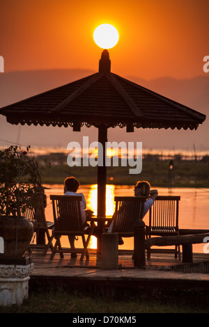 Tourists relaxing during a sunset over Inle Lake, Nyaung Shwe, Shan State, Myanmar, (Burma) Stock Photo