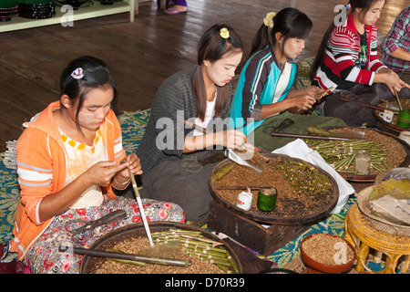 Young women making cheroots in a cheroot making factory, Nampan, Inle Lake, Shan State, Myanmar, (Burma) Stock Photo