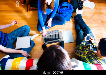 overhead view of a group of teens on the floor working on a project using various means and technologies.  multi media concept Stock Photo