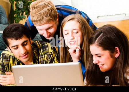 a group of teens viewing a computer screen together. High saturation. Stock Photo