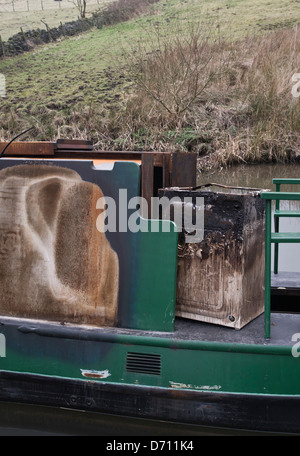 fire damaged narrow boat and burnt out washing machine peak forest canal Stock Photo