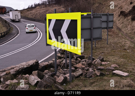 warning road sign next to broken damaged walling stone a628 woodhead bend Longdendale trail Derbyshire Stock Photo