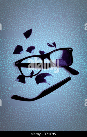 broken sunglasses on a wet table Stock Photo