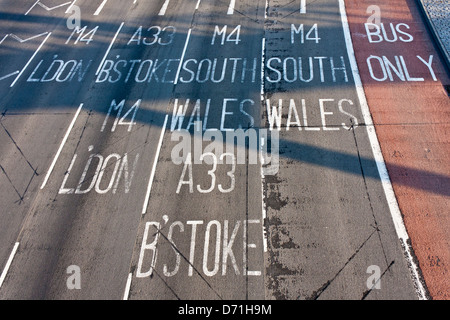 Painted destination signs on road lanes to the M4 motorway at junction 11 in Reading, Berkshire.