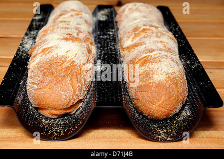 Freshly baked French baguettes in a baguette tray. Stock Photo