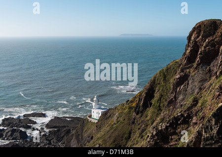 Hartland Point, Hartland, North Devon, England. The Harland Point lighthouse at the foot of the cliffs with Lundy Island. Stock Photo