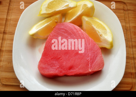 Raw Tuna Steak on a PLate with Lemon Stock Photo