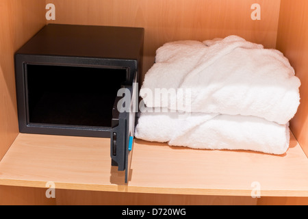 Scene in hotel room: prepared fresh bathrobes and open safe at closet shelf Stock Photo