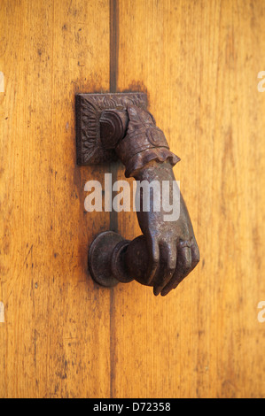 Old bronze knocker on a wooden door Stock Photo