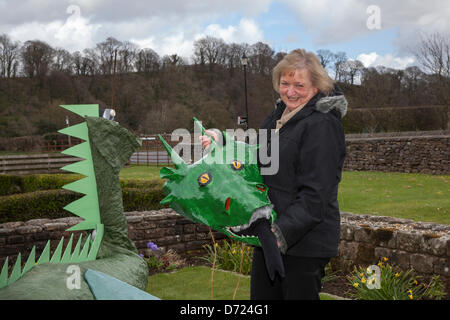 Wray, Lancaster, Friday 26th April, 2013. Christine Stebbing, 66 holding dragon's head at the Scarecrow Festival, established 1995 with wacky scarecrows constructed by the villagers to raise funds for charities, including the church and local school. The theme for 2013 is “I read – Books”  a ‘cultural’ highlight of the Lune Valley's calendar.  Thousands of visitors come to the village to admire the skill and humour of the local residents and it really is a great display of community spirit. Stock Photo