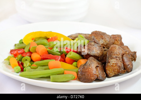 Boiled vegetables with chicken liver on white plate Stock Photo