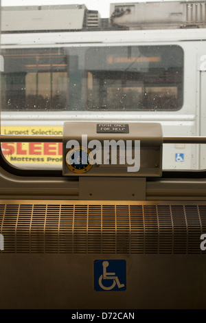 Sign indicates spot for wheelchairs on the Green line trolley and subway cars in Boston and suburbs. Note button for assistance Stock Photo