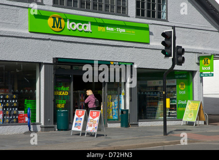 Woman going into M Local, a small branch of Morrisons, in Windermere, Lake District National Park, Cumbria, England UK Stock Photo