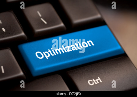 Blue key with Optimization word on laptop keyboard. Stock Photo