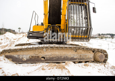 closeup of caterpillar excavator tractor driver cabin covered with snow in winter. heavy machinery industry. Stock Photo