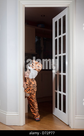 Playful child dressed in tiger costume,plays hide and seek Stock Photo