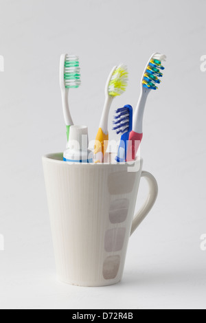 Toothbrushes and toothpaste in a mug Stock Photo