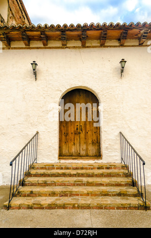 A wooden colonial door on the side of an old church Stock Photo
