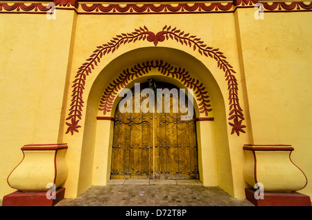 Intricate artwork of the entrance to a yellow and red church in Mexico Stock Photo