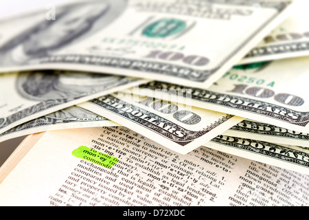 The word money in dictionary with dollars Stock Photo