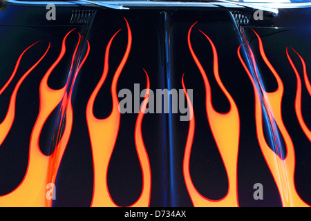 A flame design paint job adorns the hood of a classic car. Stock Photo