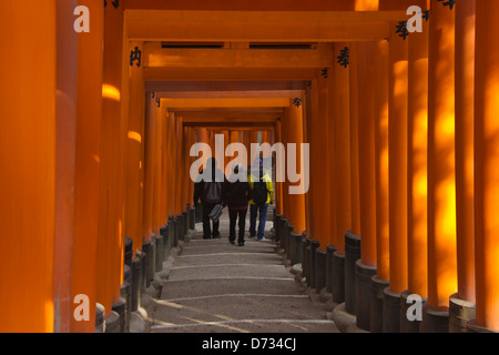 Tourist walking through the columned stairway, Fushimi Inari shrine, Kyoto, Japan Stock Photo