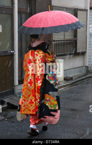 Geisha in kimono with umbrella walking on the street in rain, Asakusa, Tokyo, Japan Stock Photo