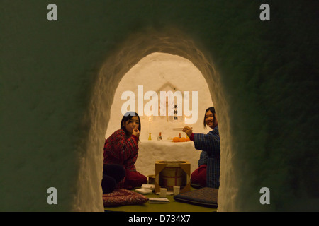 Tourists eating rice cakes in igloo-like snow houses at Kamakura Festival, Yokote, Akita Prefecture, Japan Stock Photo