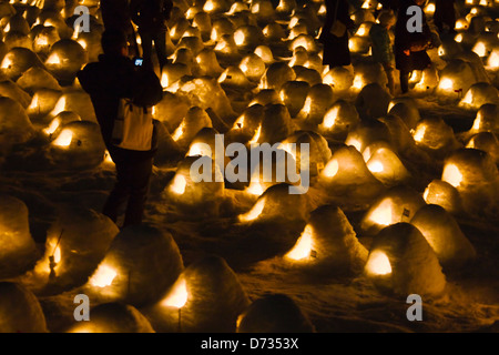 Tourist photographing miniature igloo-like snow houses at Kamakura Festival, Yokote, Akita Prefecture, Japan Stock Photo