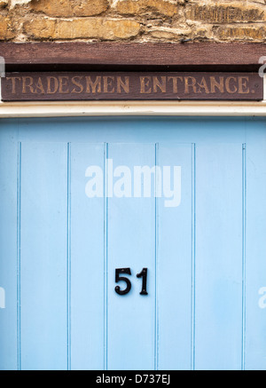 Tradesmen Entrance door sign above a blue wooden front door. UK Stock Photo