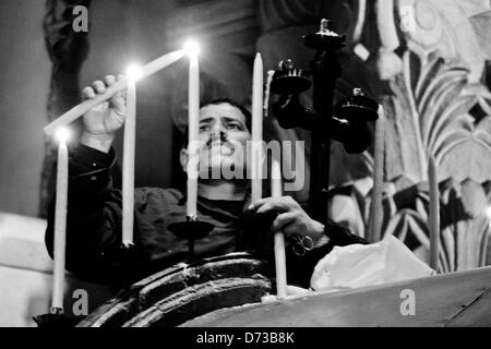 A man lights candles above the Coptic Chapel in the Church of The Holy Sepulchre. Jerusalem, Israel. 28-April-2013.  Eastern Orthodox Christians celebrate Palm Sunday, based on the Julian calendar, at the Church of The Holy Sepulchre. Stock Photo