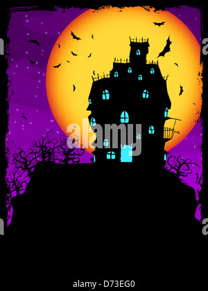 Haunted House on a Graveyard hill at night with full moon. Stock Photo