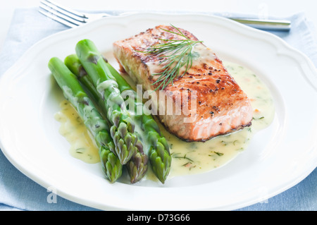 Grilled salmon with asparagus and dill sauce on white plate Stock Photo